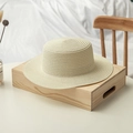 Detailansicht eines cremefarbenen Strohhuts mit flacher Krone auf einem Holztablett - M (56-58cm) / Creme