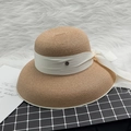 Detail of elegant khaki straw hat with cream satin bow and gold M metal emblem badge - M / Khaki