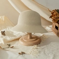 Handwoven straw sun hat for girls in beige displayed on a wooden stand for beach travel - 52 / Off White