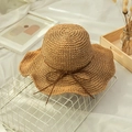 Nahaufnahme von handgewebtem Strohhut mit Schleifendetail und gewellter Krempe - M (56-58cm) / Khaki