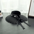 Close-up of black straw sun hat with pearl embellishments and a satin bow decoration - M (56-58cm) / Black