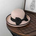Detailaufnahme eines rosa Strohhuts mit großer schwarzer Schleife auf Holztisch - M (56-58cm) / Fleischrosa