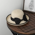 Dettaglio di un cappello di paglia con grande fiocco nero su piano in legno - M (56-58cm) / Bianco Sporco