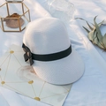 Détail d'un chapeau de soleil en paille blanche avec nœud noir et bouton en bois - M (56-58cm) / Blanc décoloré