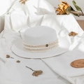 Detail of white straw hat featuring a gold letter M emblem and rustic fringe ribbon trim - M (56-58cm) / Bleached White