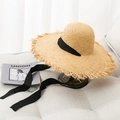 Handmade wide brim raffia sun hat with frayed edges and black ribbon on a sofa - Black Strap
