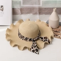 Straw sun hat with leopard ribbon bow and wide wavy brim for women on a desk - M (56-58cm) / Beige