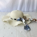 Detalle de un sombrero de paja beige con bordes ondulados, perlas y cinta floral - M (56-58cm) / Blanco Leche