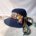 Detail of navy straw sun hat featuring a vibrant floral ribbon and large side bow tie - M / Navy Blue