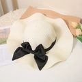 Beige wide-brim straw hat with black silk bow on wave-shaped wooden tray with tulips - M / Milk White