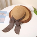 Detail of two-tone straw hat featuring a large ribbon bow and wavy brim on a table - M (56-58cm) / Khaki with Caramel Edge