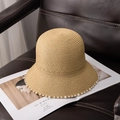 Detalle de un sombrero de paja con adornos de perlas sobre una revista y asiento de cuero - M (56-58cm) / Caqui