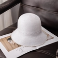 Detalle de un sombrero de paja blanco con adorno de perlas sobre silla de cuero - M (56-58cm) / Blanco Blanqueado