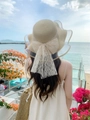 Detail of beige straw sun hat with white lace bow and elegant organza wavy brim - M (56-58cm) / Beige