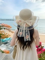 Detailansicht eines Strohhuts mit eleganter floraler Spitzenbandschleife und Netzschleife - M / Beige