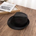 Close-up of black woven straw fedora hat texture with ribbon on dark wooden table - L / Black