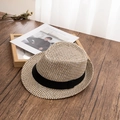 Detailansicht der Strohhut-Struktur mit schwarzem Band auf einer Holzoberfläche - M / Beige