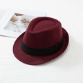 Close-up of wine red wool felt fedora with black ribbon band on a textured background - M / Burgundy