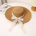 Detalle de sombrero de paja de ala ancha con lazo de encaje blanco y cintas elegantes - M / Caqui
