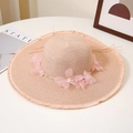 Detail of woven straw sun hat with pink chiffon flowers and pearl accents on white desk - M / Nude Pink