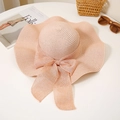 Detalle de sombrero de paja rosa miel con ala ancha, borde ondulado y lazo decorativo - M / Rosa Carne