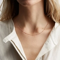 Elegante collana a sfere in oro rosa per donna indossata da modella con camicia beige - Catena a Sfere (38+5CM) - Oro