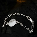 S925 sterling zilveren armband met witte ovale edelsteen op donker houten achtergrond - 925 zilver / Witgoud