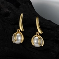 Elegantes pendientes colgantes dorados con perlas blancas sobre una superficie negra - Plata 925 / Oro de 18K