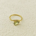 Gros plan sur un zircon vert en forme de poire sur une bague dorée ondulée - Août Vert Clair (Couleur Péridot)
