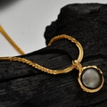 Golden S925 silver necklace featuring a round iridescent dark shell pendant on charcoal - 925 Silver / Antique Gold