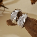 Polished silver twist hoop earrings with pavé set cubic zirconia on dark wood base - 925 Silver / Platinum (With Silver Ear Plugs)