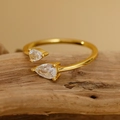 Adjustable gold S925 silver ring featuring two teardrop cubic zirconia on a wooden base - Size 14 (Open Adjustable) / 18K Gold