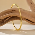 Minimalist S925 sterling silver open bangle with a polished gold finish on wood branch - 925 Silver / 18K Gold