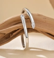 Macro shot of S925 silver open ring with teardrop zircon on a natural wood branch - 925 Silver / White Gold