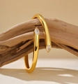 Macro detail of gold-plated pear-shaped zircon stones on a sleek wrap bangle - 925 Silver / 18K Gold