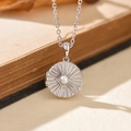 Collana con medaglione d'argento, incisione a raggiera e perla su libro d'epoca - Argento 925 / Oro Bianco