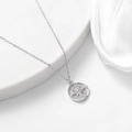 Close-up of S925 sterling silver compass coin pendant on white silk fabric background - 925 Silver / White Gold