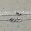 Dettaglio del bracciale infinity in argento sterling S925 con zirconi incastonati - Argento 925 / Oro Bianco