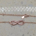 Dettaglio del bracciale a infinito oro rosa con zirconi incastonati e chiusura a moschettone - Argento 925 / Oro rosa