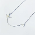 Macro shot of silver swallow pendant necklace with sparkling round cubic zirconia - Full 925 Sterling Silver / White Gold