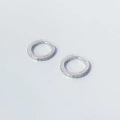 Dettaglio del marchio S925 e dell'intarsio di zirconi sugli orecchini a cerchio in argento - Argento 925 / Oro Bianco