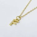 Macro view of gold letter F pendant with small zircon inlay on a delicate O-chain - Letter F / 925 Silver Gold Plated