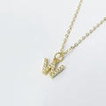 Macro shot of gold-plated letter W pendant encrusted with sparkling zircon stones - Letter W / 925 Silver Gold Plated