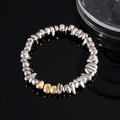 Macro shot of silver and gold hematite beads on a reflective black surface - Silver Gold Irregular Beading (S554-B)