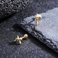 Vista macro di orecchini a croce dorati con zircone verde e chiusure a sfera - Stile Oro con Intarsio di Pietra Verde (X1154-D)