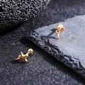 Close-up of gold titanium ear studs featuring a cross floral design with red zircon stones - Red Stone Inlaid Gold Style (X1154-E)