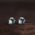 Detalle macro de aretes de serpiente plateados retro con topacio azulino - Plata Antigua con Piedra Azul Claro