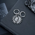 Dettaglio degli orecchini argento con sole e luna su sfondo di un libro nero antico - Orecchini in argento asimmetrici Sole Luna