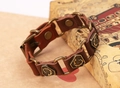 Dettaglio del bracciale in pelle marrone vintage con motivi di scorpione e bottoni a pressione - Marrone