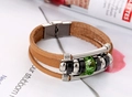 Detailansicht eines braunen mehrlagigen Lederarmbands mit grünem Kristall im Vintage-Stil - Hellbraun